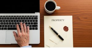 Property Scams Targeting Seniors in South Africa. An older hand rests confidently on a laptop keyboard.